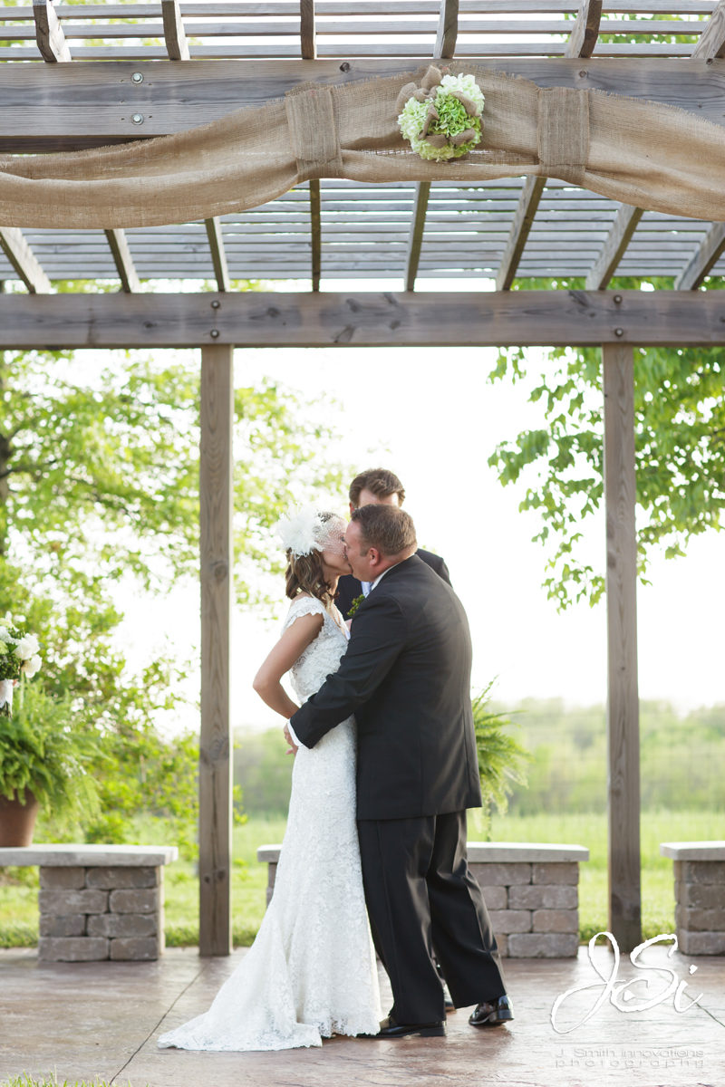 Kansas City country rustic wedding ceremony bride groom first kiss picture
