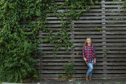 Kansas City laid back senior photographers girl ivy wood wall