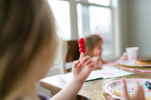 fun authentic picture of kid being kid wit raspberries on her finger documentary photo