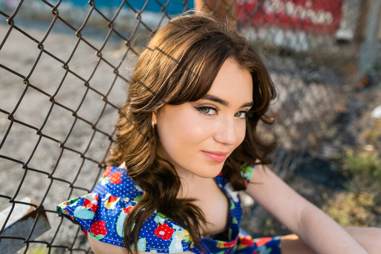 senior picture on fence with personalty in Overland Park