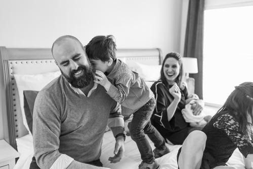 KC documentary newborn family photographers authentic real moment of boy hugging dad photo