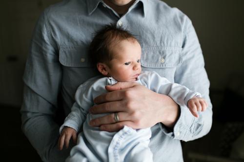 KC newborn photographer sweet baby being held by dad in calm relaxed photo