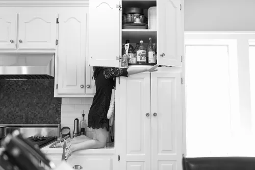 Kansas City day in the life family documentary session genuine fun storytelling moment girl getting snack in cabinet picture