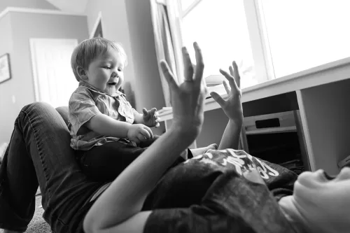 Kansas City husband wife documentary photographers funny laughing picture of boy playing with mom