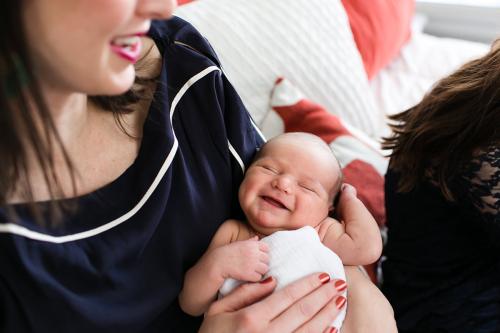 adorable smiling baby being held by new mom