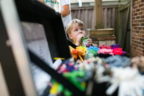 birthday party kid with juice box looking up at ballon artist authentic funny moment