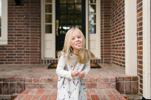candid silly girl sticking tongue out during genuine relaxed children's photo session