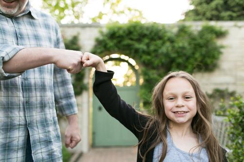 fun genuine moment girl fist bumping dad