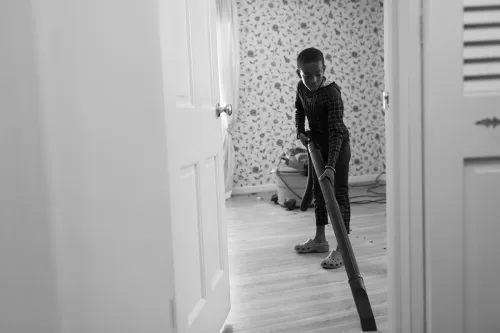 fun photo of kid vacuuming floor in spiderman outfit