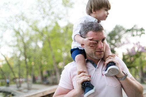 fun pic of kid grabbing dads face during relaxed family picture session