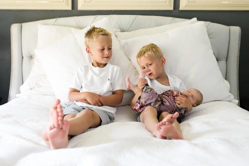 funny cute moment of brothers looking at new baby's feet