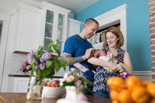 genuine moment of mom dad and baby smiling at newborn session