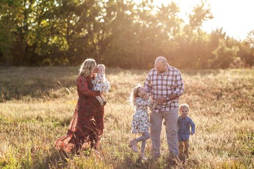 happy family in field during golden hour picture