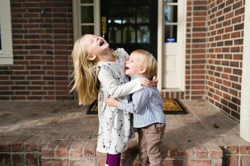 happy kids laughing together at in-home family photo session