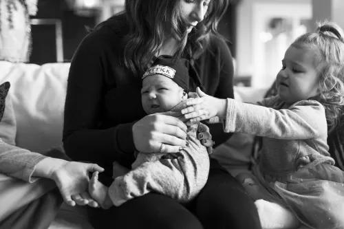 in-home session real life sister really wanting to hold newborn