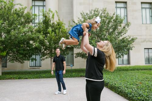 mom tossing daughter in air fun family photo session