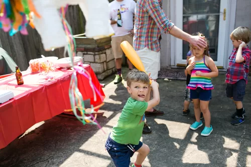 silly kid swinging bat at piñata at birthday party