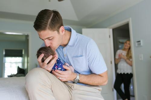 storytelling newborn lifestyle session dad kissing baby on forehead photo