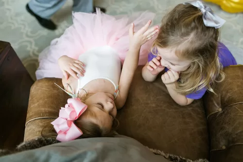 sweet photo of two little girls sharing a ream moment at birthday party documentary moment