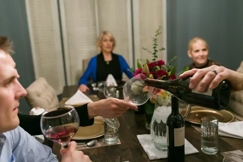 wine being poured at family dinner picture